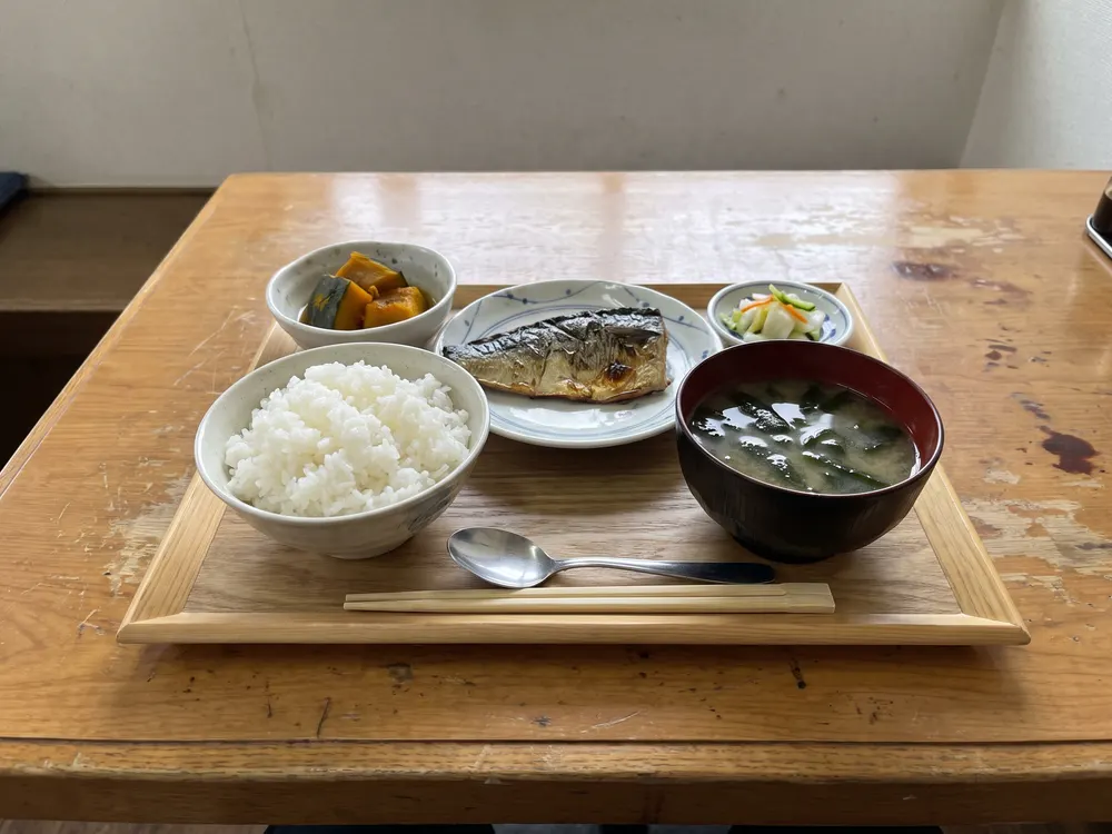 盆にのせた、ご飯とみそ汁と焼き魚の昼食