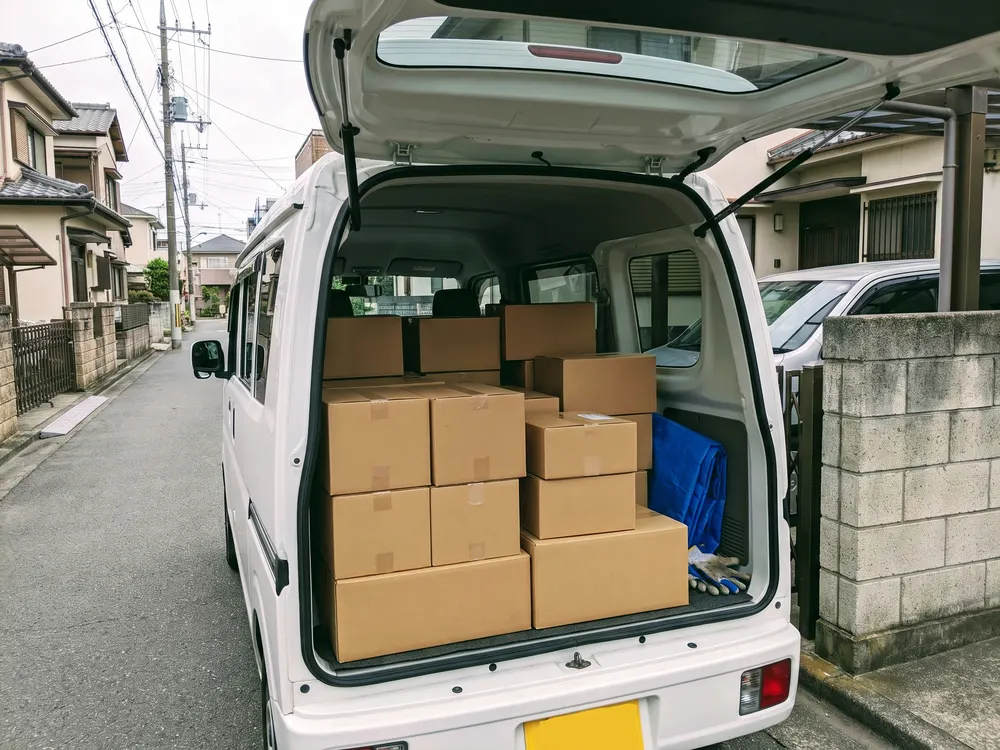 軽自動車の荷台に順に並べた段ボール箱