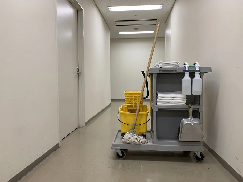 廊下に置いた、モップとバケツを載せた清掃の台車